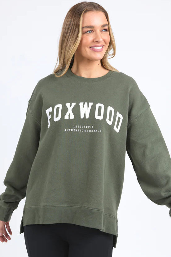 Woman wearing a green sweatshirt with 'FOXWOOD' branding on a white background