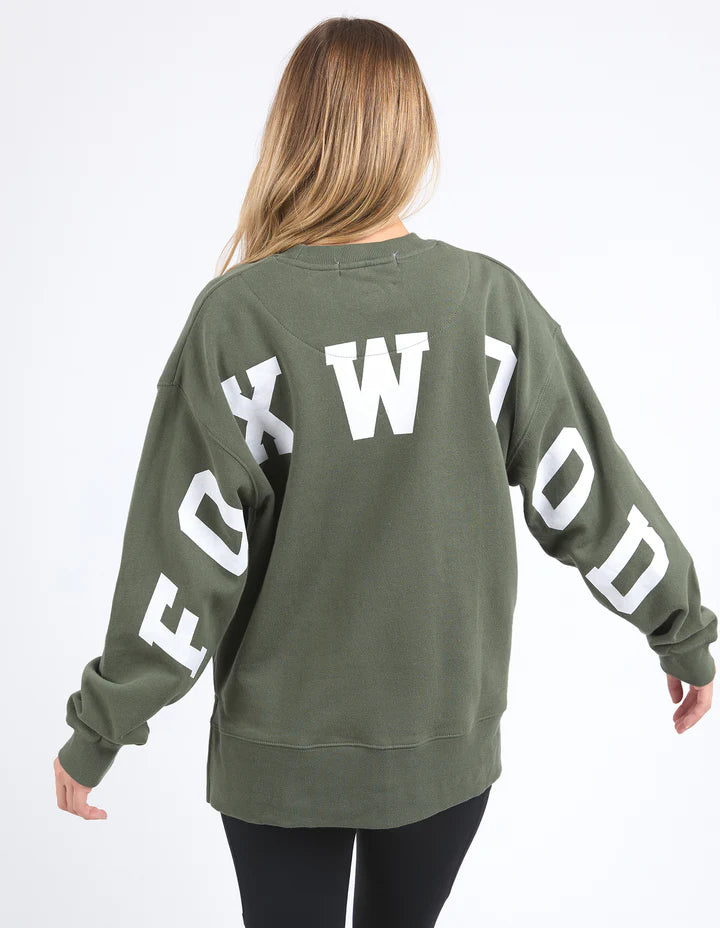 Woman wearing a green sweatshirt with 'FOXWOOD' branding on a white background