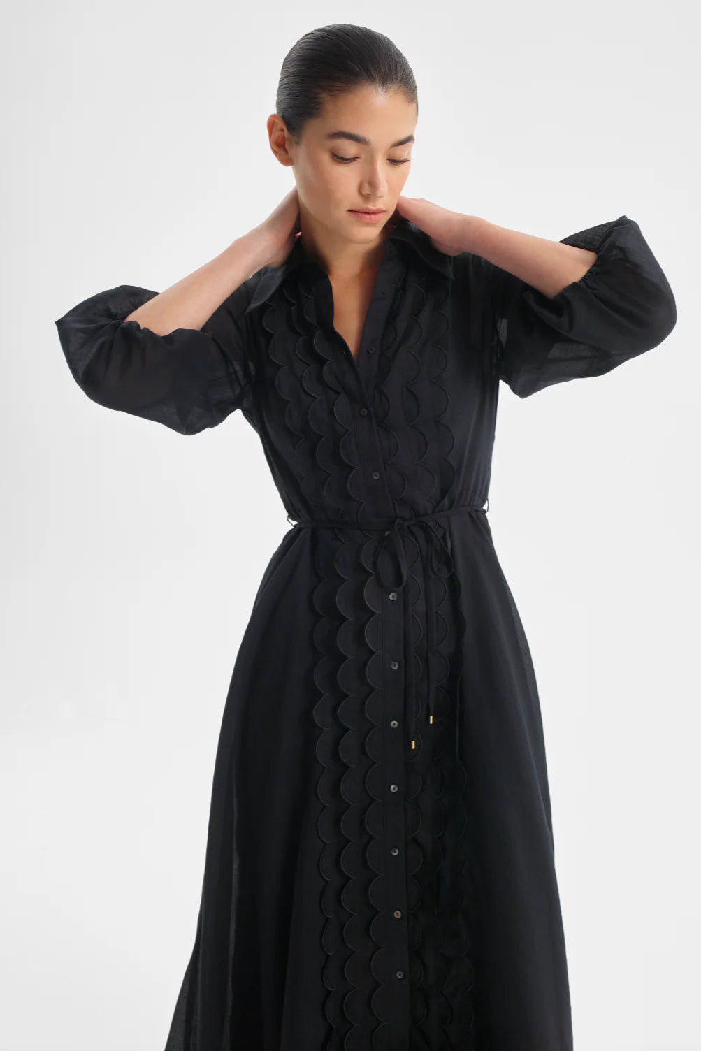 Woman wearing a black dress with a white background